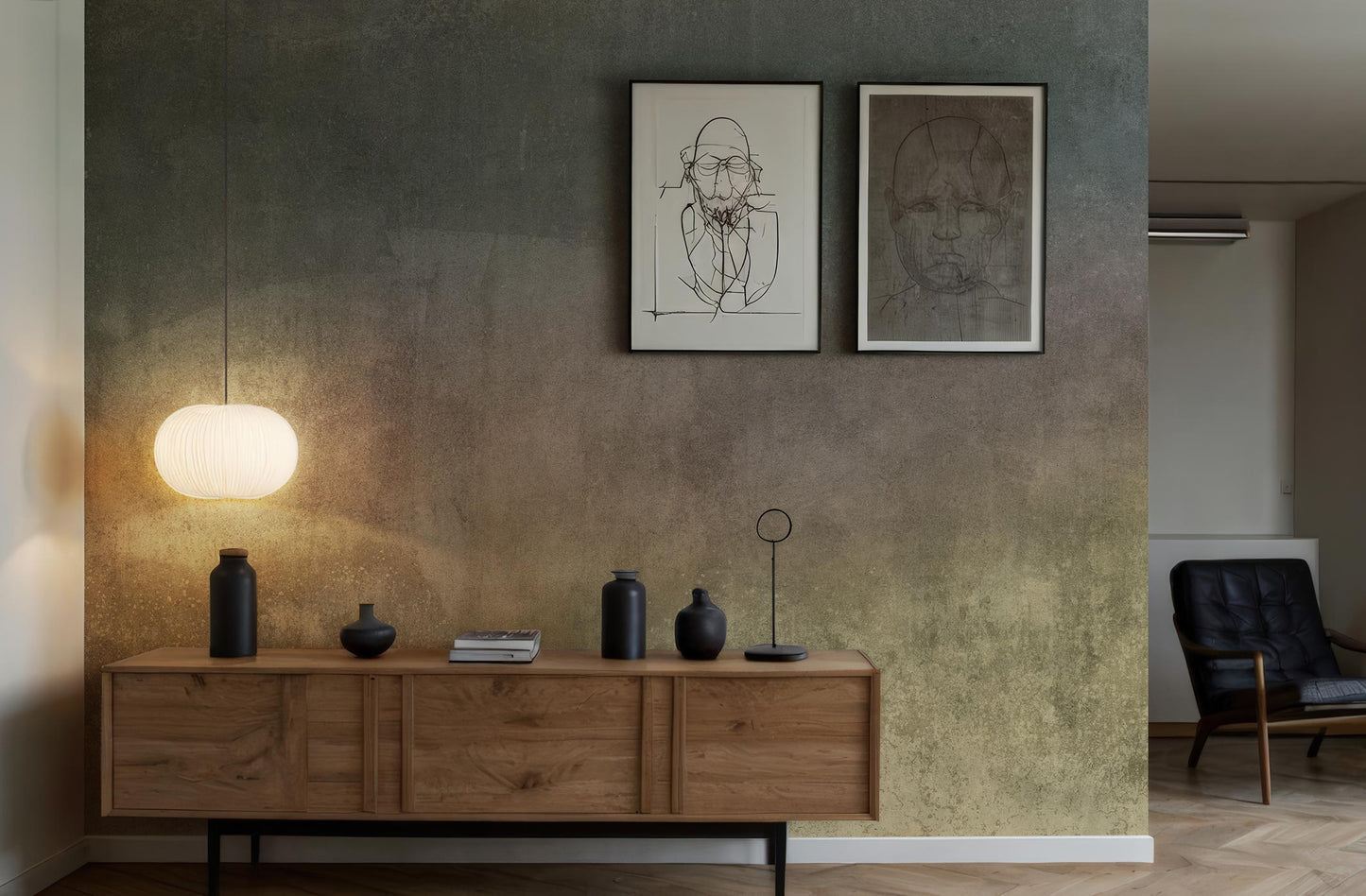 Mehrfarbige Designtapete von Superwalls in sanften Tönen. Holzsideboard mit mehreren schwarzen Dekorationsobjekten und einer Stehlampe. Zwei gerahmte Zeichnungen an der Wand.