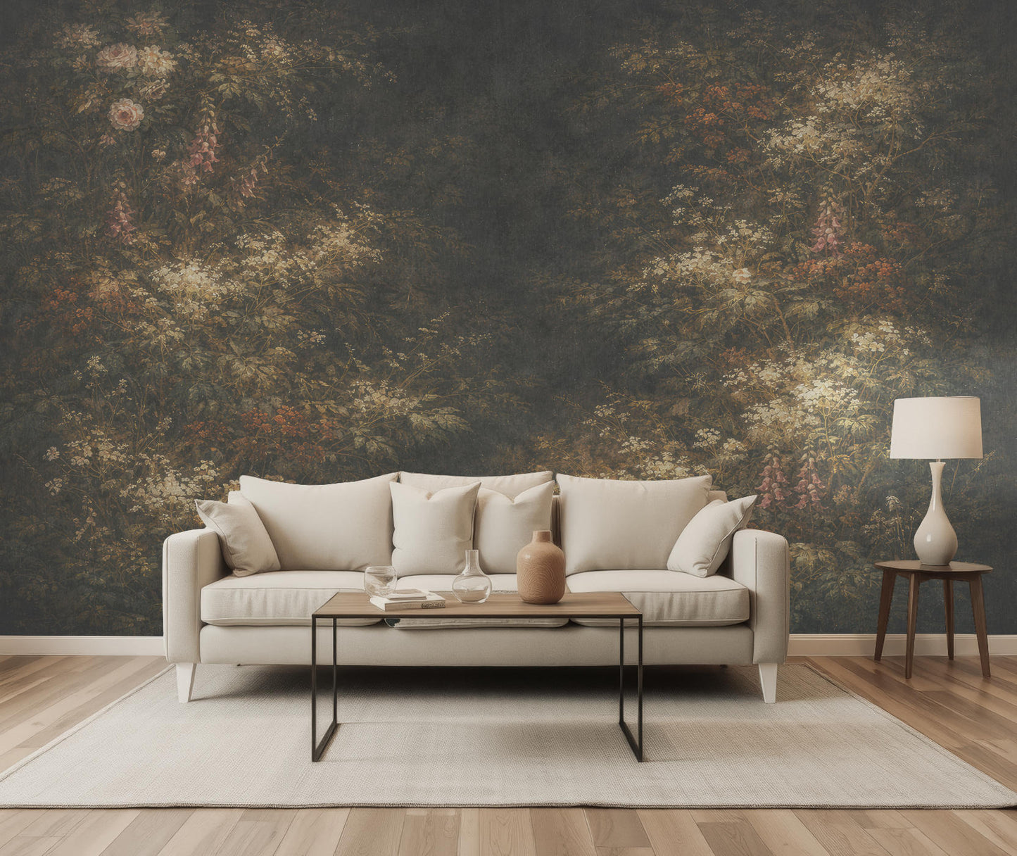 Beige Sofa mit Kissen vor einer Wand mit einer floralen Vliestapete von Superwalls davor ein niedriger Tisch mit Dekoration, rechts ein Beistelltisch mit weißer Lampe