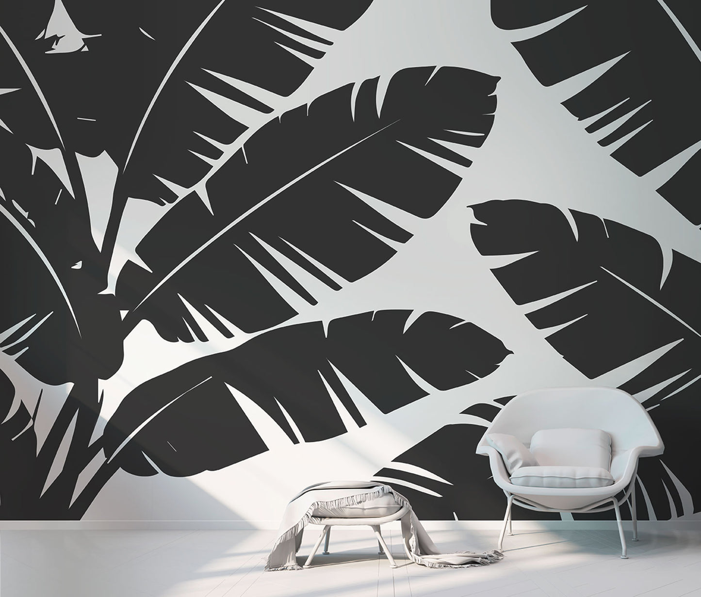 Schwarz-weiße Tapete von Superwalls mit großflächigem Blattmuster und weißem Sessel mit Kissen daneben