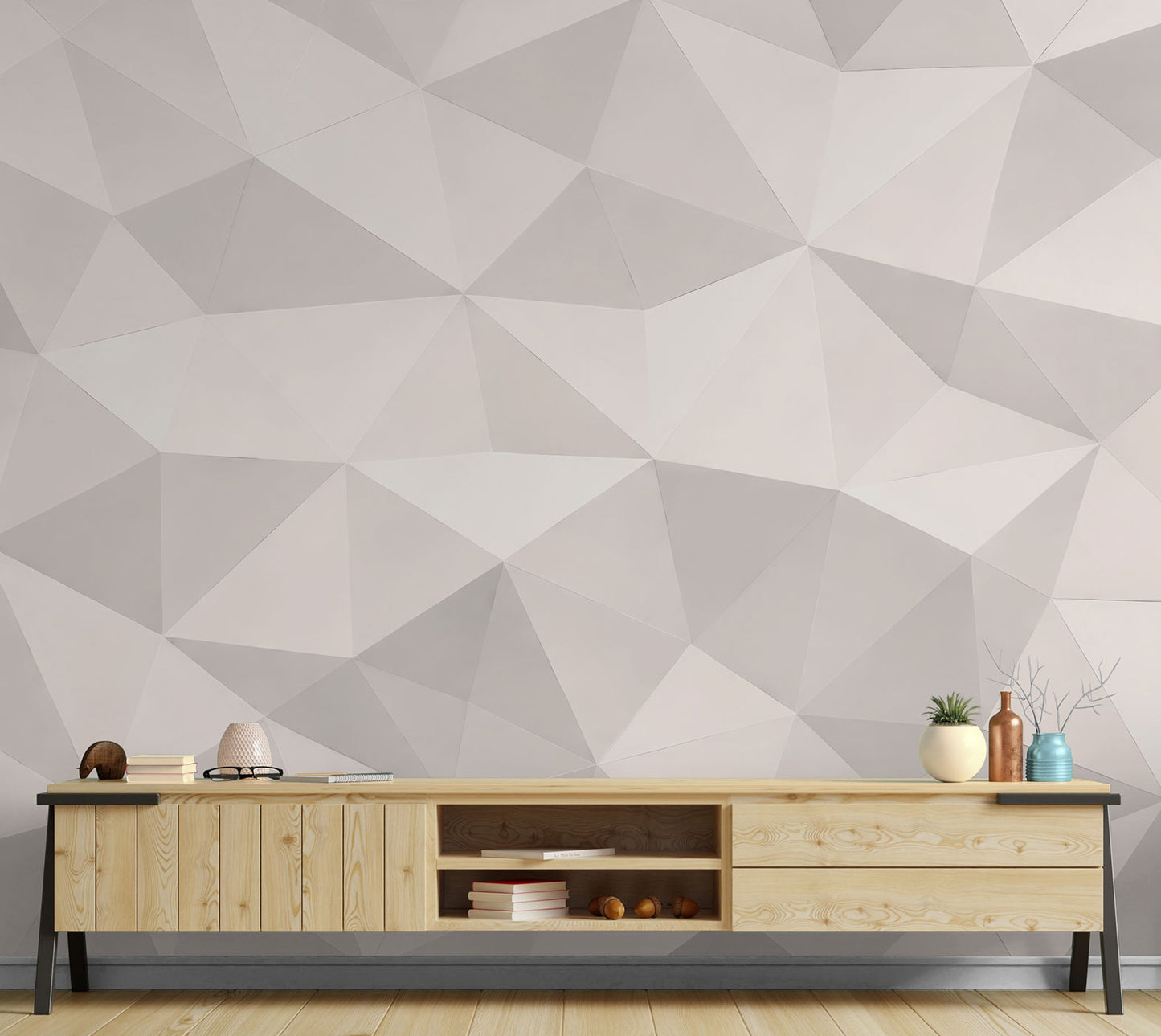 Niedriges Sideboard aus hellem Holz mit Büchern, Brille, Dekoobjekten und Pflanzen vor einer Tapete von Superwalls  mit geometrischem Muster