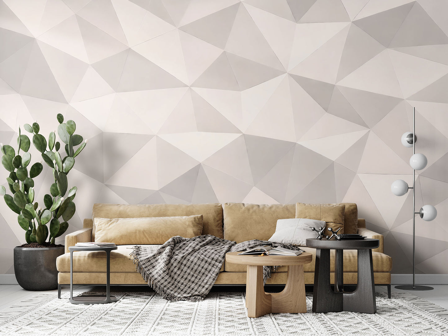 Beige Couch mit Kissen und kariertem Plaid vor einer Tapete von Superwalls mit geometrischem Muster neben einem großen Kaktus und zwei runden Couchtischen