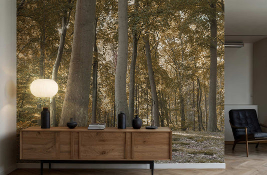 Holzsideboard mit Dekoration vor einer Wandtapete mit Waldmotiv von Superwalls, daneben ein schwarzer Sessel in einem modernen Raum.