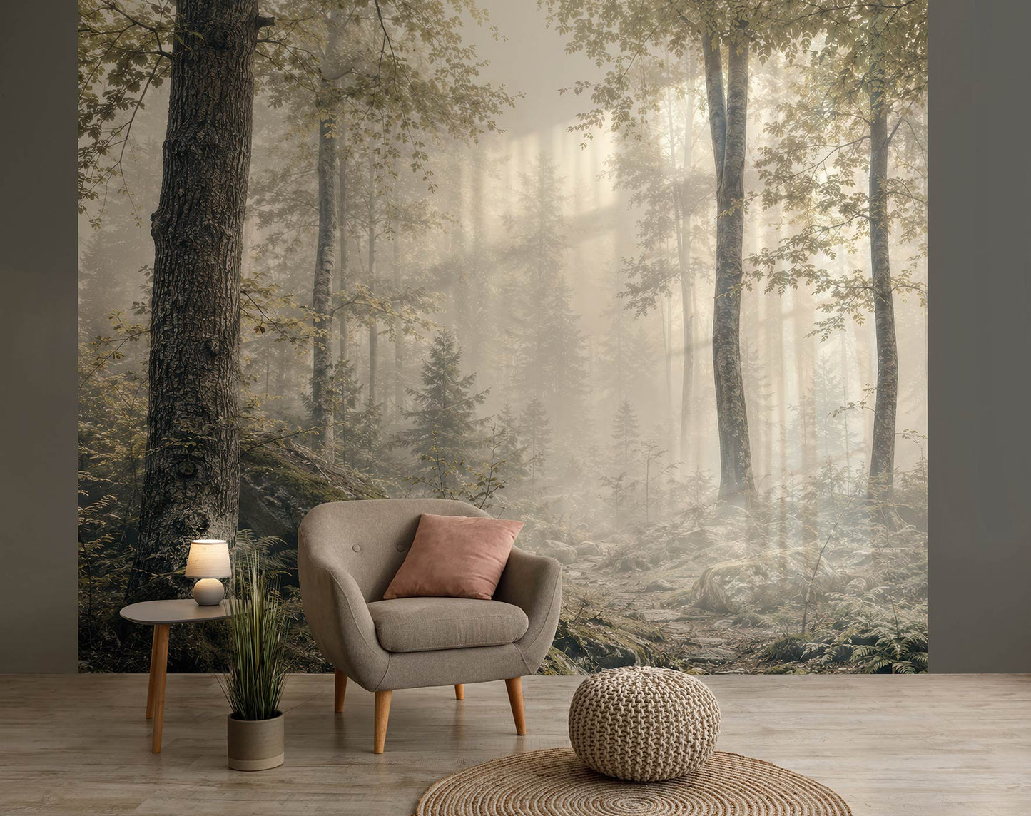Wohnzimmer mit grauem Sessel, rosa Kissen, kleinem Beistelltisch mit Lampe, Pflanzen und einer Tapete mit nebligem Waldmotiv von Superwalls