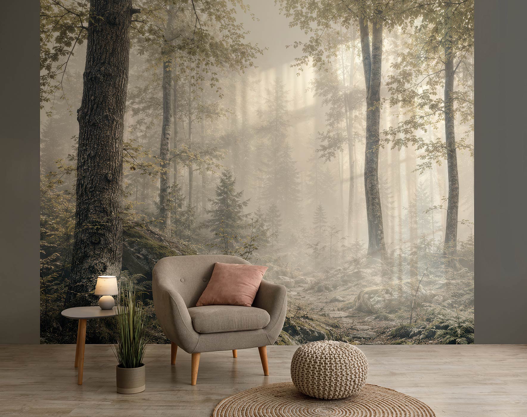 Wohnzimmer mit grauem Sessel, rosa Kissen, kleinem Beistelltisch mit Lampe, Pflanzen und einer Tapete mit nebligem Waldmotiv von Superwalls