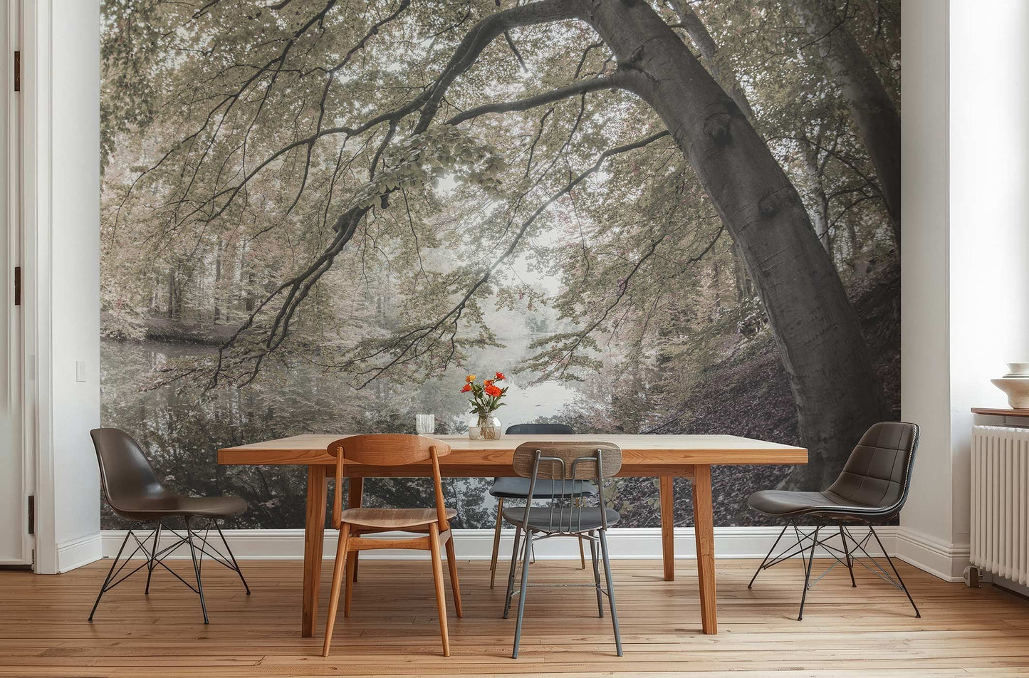 Esszimmer mit Holztisch, verschiedenen Stühlen und einer Fototapete mit großem Baum und Waldlandschaft von Superwalls