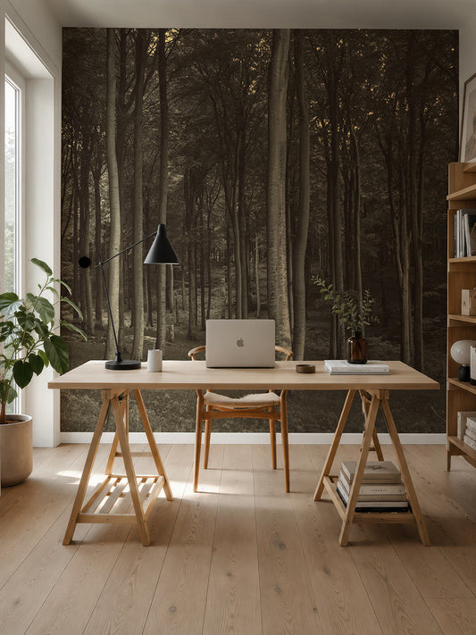Schreibtisch mit Laptop, Lampe und Pflanzen vor einer Wand mit großformatiger Fototapete mit Waldmotiv von Superwalls