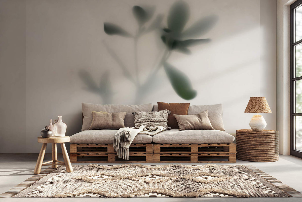 Wohnzimmer mit Sofa aus Holzpaletten, mehreren Kissen, einem Beistelltisch mit Vasen, einem runden Korb mit Lampe und einem Teppich vor dem Sofa. Botanische Fototapete von Superwalls