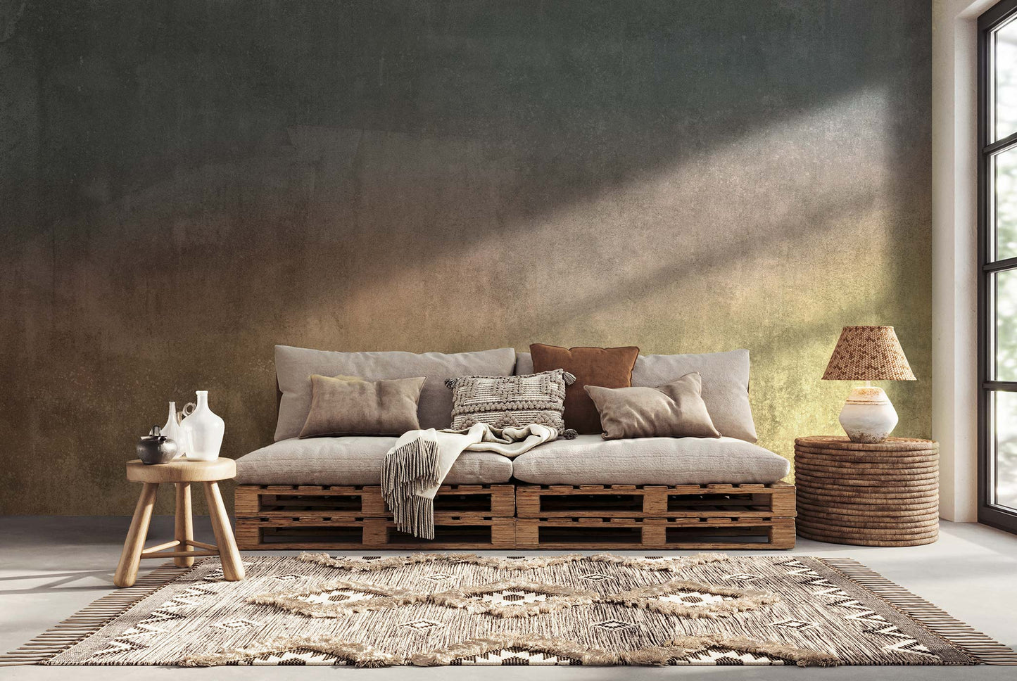 Wohnzimmer mit einer mehrfarbigen Designtapete von Superwalls. Ein Sofa aus Holzpaletten mit Kissen, ein runder Tisch mit einer weißen Vase, ein geflochtener Korb und ein Teppich.